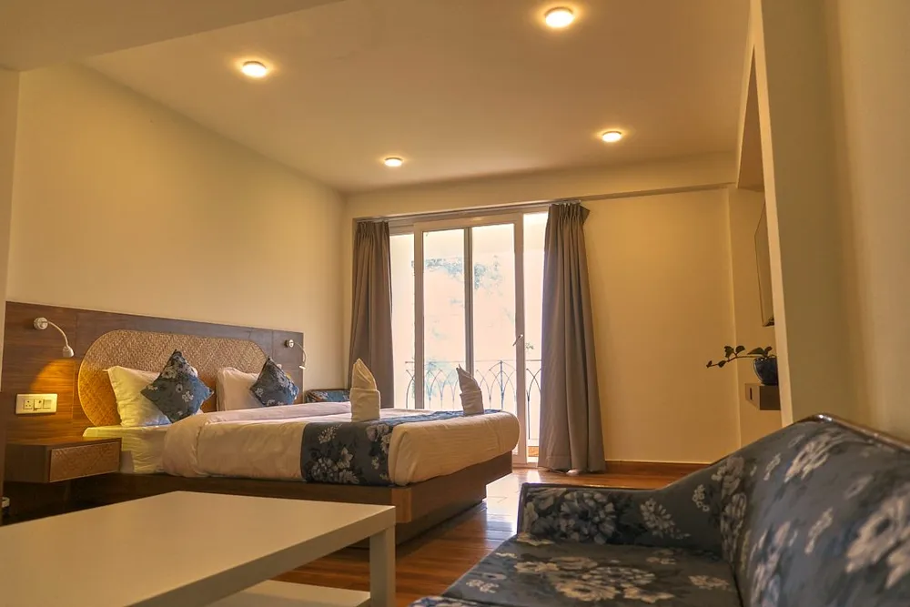 Warmly lit bedroom with a sofa and balcony doors