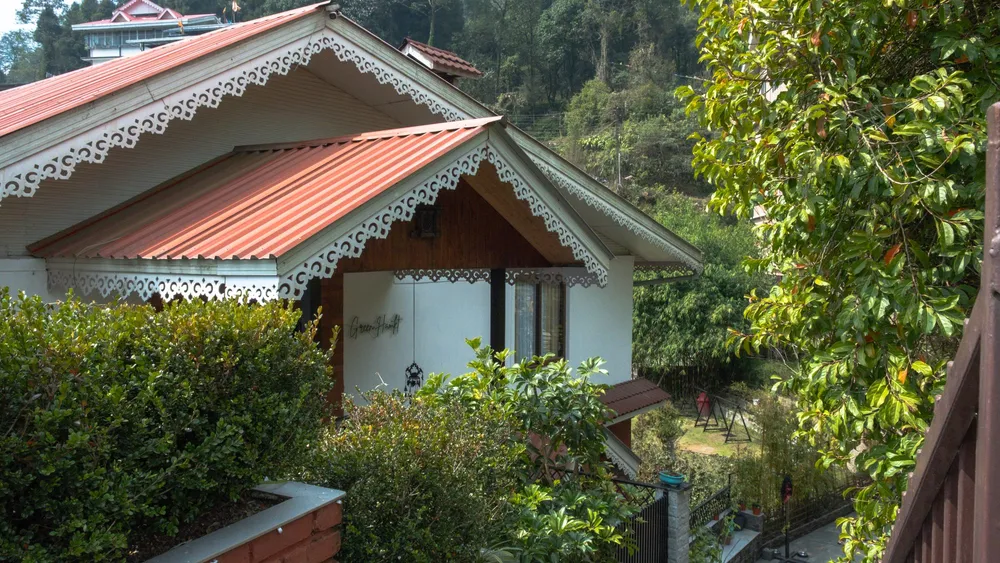 Wooden cottage with a red roof among the trees at Green Hamlet