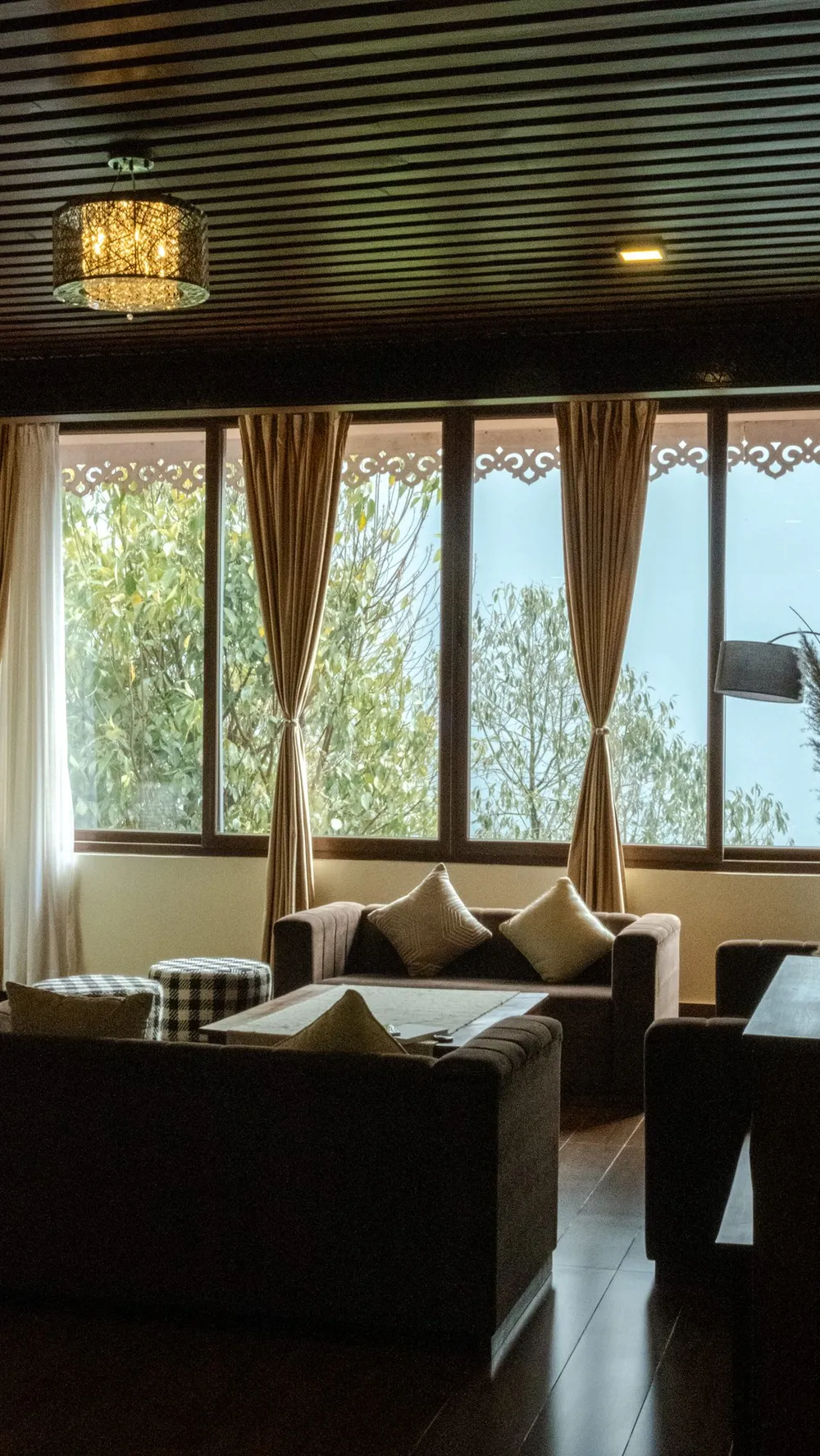 Lounge with sofas and tall windows looking out onto the hills